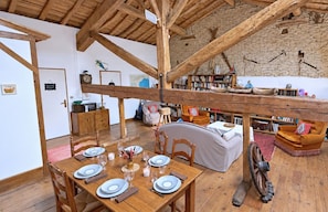 A rustic interior with a dining area, a sofa, and a bookshelf. - Spacious 190 m² Holiday Home, Billiards, Memorable Gatherings near Canal du Midi (lagarde)