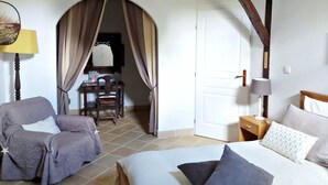 Een kamer met een bed, een stoel, een bureau en een kledingkast.