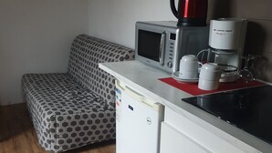 A compact kitchenette with a microwave, coffee maker, and a small refrigerator. - L (Saint-Amand-Montrond)