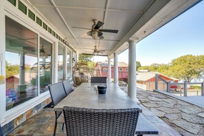 A covered patio with a table and chairs, a ceiling fan, and a view of the surrounding area. - 3BR/3BA Home w/ Pool, Fire Pit & Lake View (Granbury)