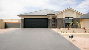 A modern two-story house with a garage, a driveway, and a landscaped front yard. - Calm Waters, Moonta Bay (Moonta Bay)
