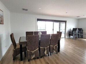 Un área de comedor con una mesa, sillas, una ventana y una puerta.