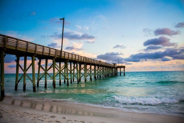 A pier extending into the ocean with a clear sky above.