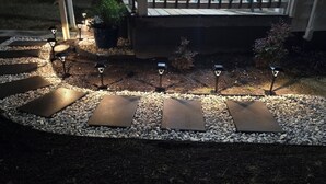 Un sendero con piedras y luces decorativas.