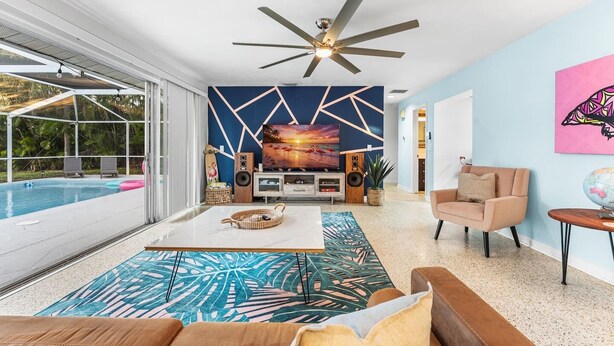 Un amplio salón con piscina, muebles modernos y un mural grande en la pared.