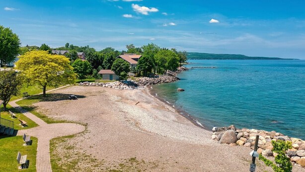 A beach with a pebble path, a small building, and a view of the water. - Family friendly summer getaway, short walk to beach, restaurants, etc... (Meaford)