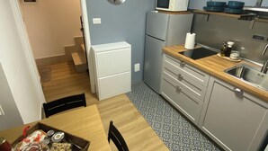 A compact kitchen with a microwave, refrigerator, and wooden countertop. - Vacation home in the heart of Petralia Soprana with Breakfast (Petralia Soprana)