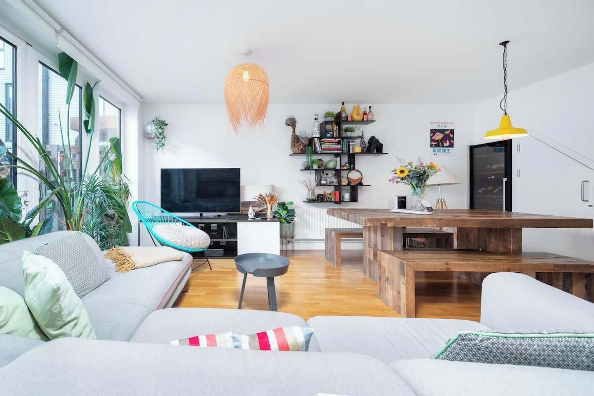 Un salon moderne comprenant un canapé, un téléviseur, une table à manger et une bibliothèque.