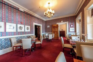 A dining area with striped wallpaper, a chandelier, and multiple dining tables and chairs. - Big Tree Treaty Room - Big Tree Inn

 (Geneseo)