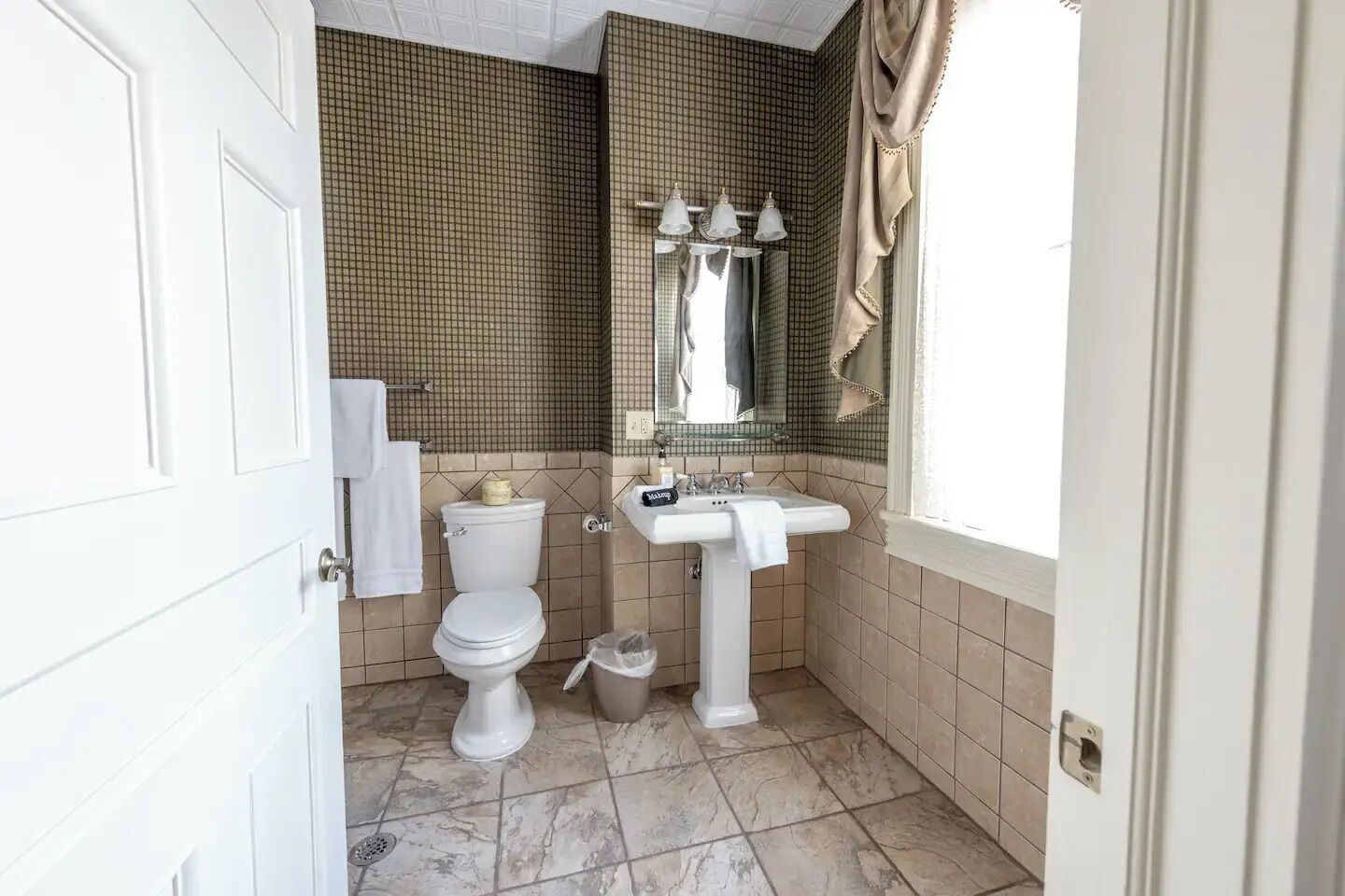 Une salle de bain avec des toilettes, un lavabo et un miroir.