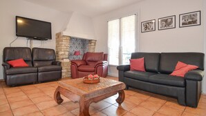 A living room with two leather sofas, a wooden coffee table, and a stone wall. - Pet friendly home in Cornillon (Cornillon)