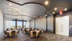 A conference room with round tables and chairs, a patterned carpet, and a large window providing a view. - Fully Furnished 2b/2b Apartment in the Galleria (Houston)