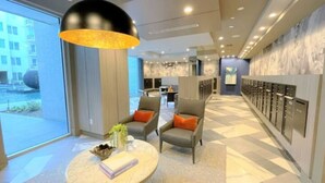 A modern hotel lobby with a seating area, a locker room, and a view of the outside. - Spacious 3B 2.5B Apt by Galleria (Houston)