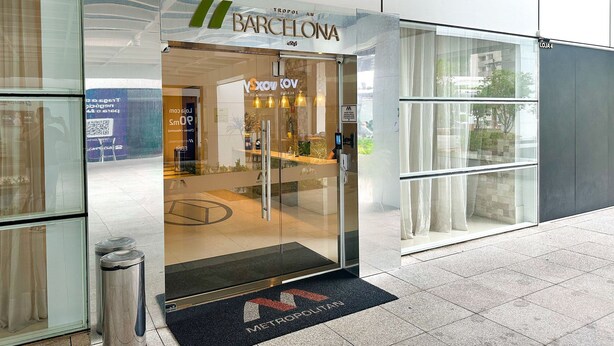 A modern hotel entrance with a glass door, a visible reception desk, and a doormat with the hotel's name. - STAY Metropolitan Barcelona  (Goiania)