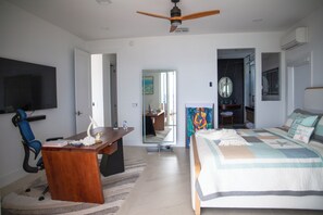 Ein Schlafzimmer mit Bett, Schreibtisch, Stuhl und Deckenventilator.
