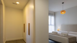 Une chambre à coucher moderne avec un lit, des lampes de chevet et une fenêtre avec des rideaux.