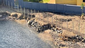 Il s’agit d’une propriété située sur la côte, dotée d’une structure à toit de chaume, d’un bâtiment jaune avec un toit en tuiles et d’une zone clôturée comprenant un plan d’eau.