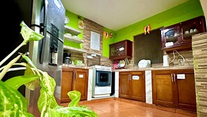 A kitchen with a refrigerator, oven, and cabinets. - Green Hostel (Moyagalpa)
