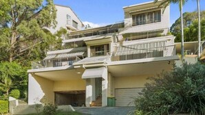 A multi-story house with a garage, balconies, and a driveway. - Currumbin Escape 2 BDR Water Views (Currumbin)