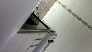 A kitchen with white cabinets, a tiled backsplash, and a stove. - Round Trip - LA06-Bertioga, SESC, Riviera, Vista Linda, Indaiá (Jardim Rafael Bertioga)