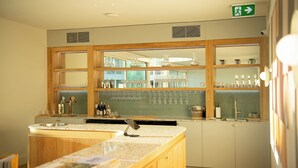 A kitchen with a bar area, wooden cabinets, and a countertop with a sink. - Kar-Rama Hotel  (Mildura)