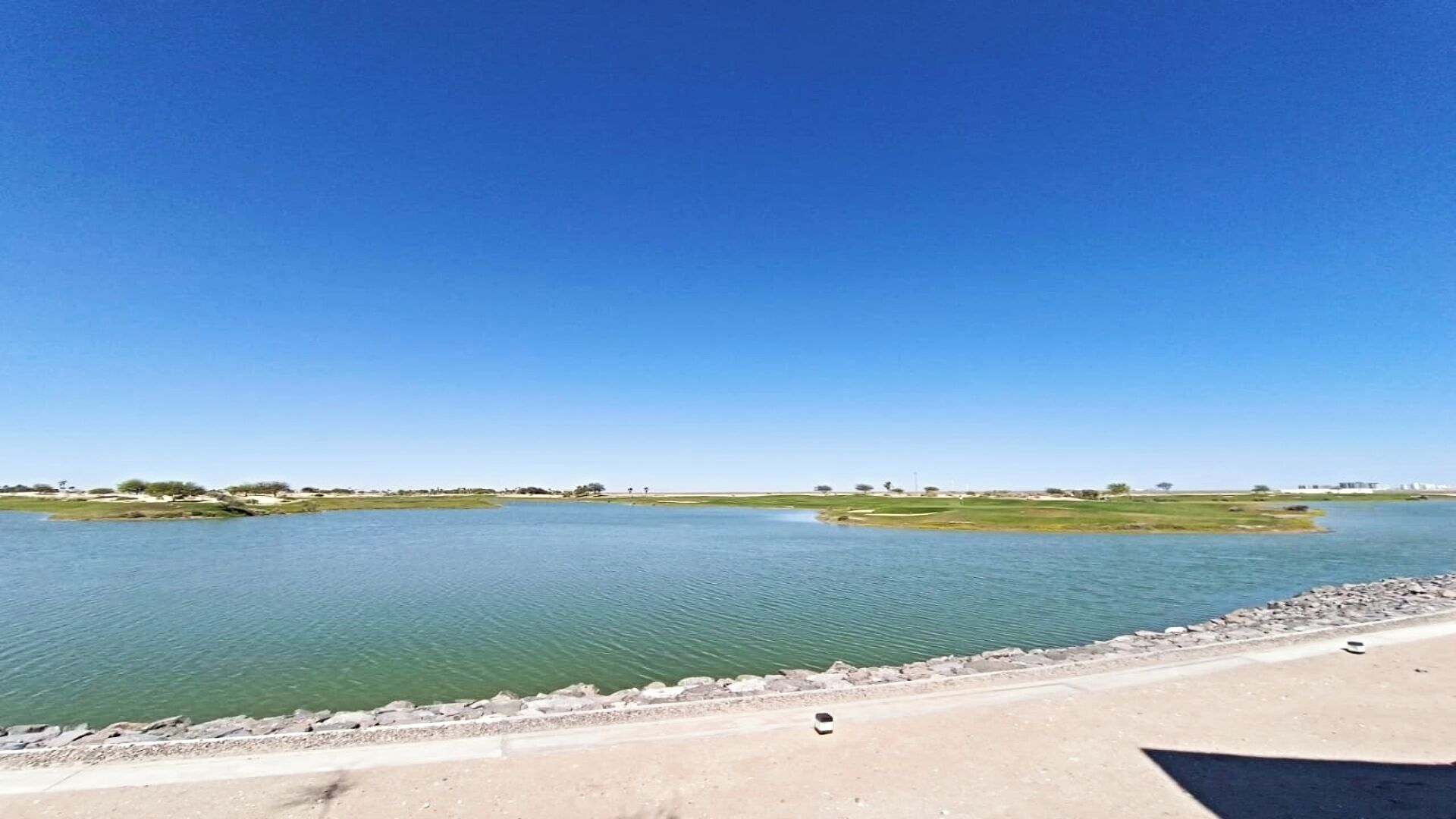 Un río con un paseo de hormigón a lo largo de la orilla.