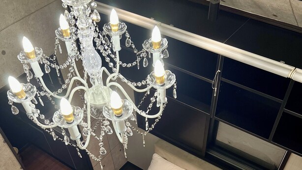 A modern bedroom with a large bed, a chandelier, and a built-in TV. - COREHOTEL (Tokyo)