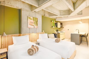 A modern hotel room with two beds, a kitchenette, and a bathroom. - Firenze Lofts (Medellín)