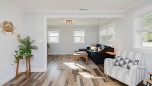 Een woonkamer met een gestreept sofa, een salontafel en een plant.