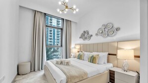 Une chambre à coucher moderne avec un grand lit, une table de chevet, une lampe et un élément décoratif mural.