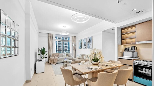 Un appartement moderne comprenant un coin repas, une cuisine et un salon.