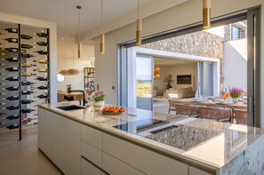 Enjoy cooking in this well-lit kitchen with a central island, sink, and stainless steel range hood.