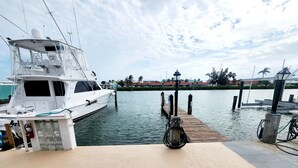 A marina with a white yacht docked at a wooden pier. - Key Colony Beach House with Cabana Club membership (Key Colony Beach)