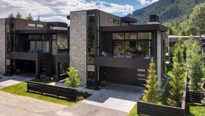 A modern two-story house with large windows, a stone facade, and a well-maintained lawn. - Abode at River Run, mountain modern, Ketchum (Ketchum)