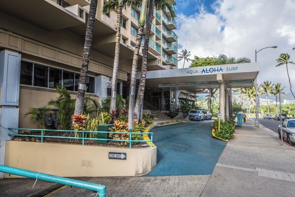 A hotel entrance with a 'One Way' sign, palm trees, and a clear sky. - Cozy Studios at Aloha Surf Close to Waikiki Beach (Honolulu)
