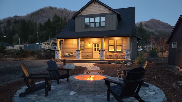 Ein Haus mit einem Steinkamin und Sitzgelegenheiten im Freien.