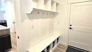 A walk-in closet with open shelving, a bench, and storage bins.