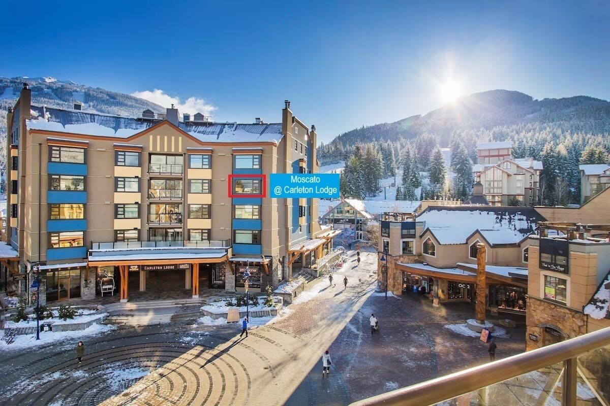 Ein Hotel mit mehreren Etagen, einem zentralen Innenhof und Blick auf schneebedeckte Berge.
