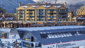 A multi-story hotel with balconies, a ski lift, and a mountainous backdrop. - Moscato-Ski-In/Ski-Out (A Condo at Carleton Lodge) (Whistler)