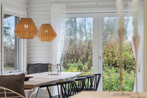 A dining area with a table, chairs, and hanging lamps.