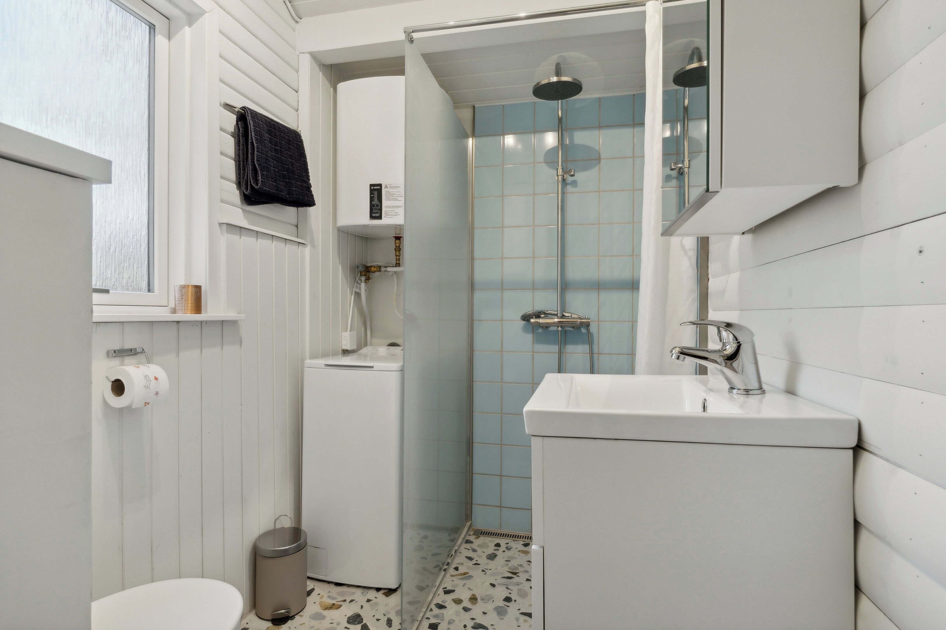 Een badkamer met toilet, wastafel en douche.