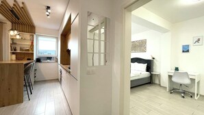 Een modern appartement met keuken, eetruimte en een slaapkamer.