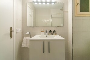 A bathroom with a white sink, a mirror, and a towel rack. - WELCS APARTAMENTO 188 PDA cerca del mar (Platja d´Aro)