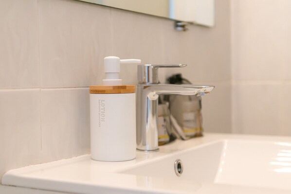A bathroom sink with a white bottle of lotion and a chrome faucet. - WELCS APARTAMENTO 188 PDA cerca del mar (Platja d´Aro)