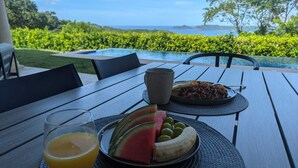 A table with a plate of watermelon, olives, and a banana, a glass of orange juice, and a cup of coffee. - A place to relax and connect with nature (Playa iguanita)