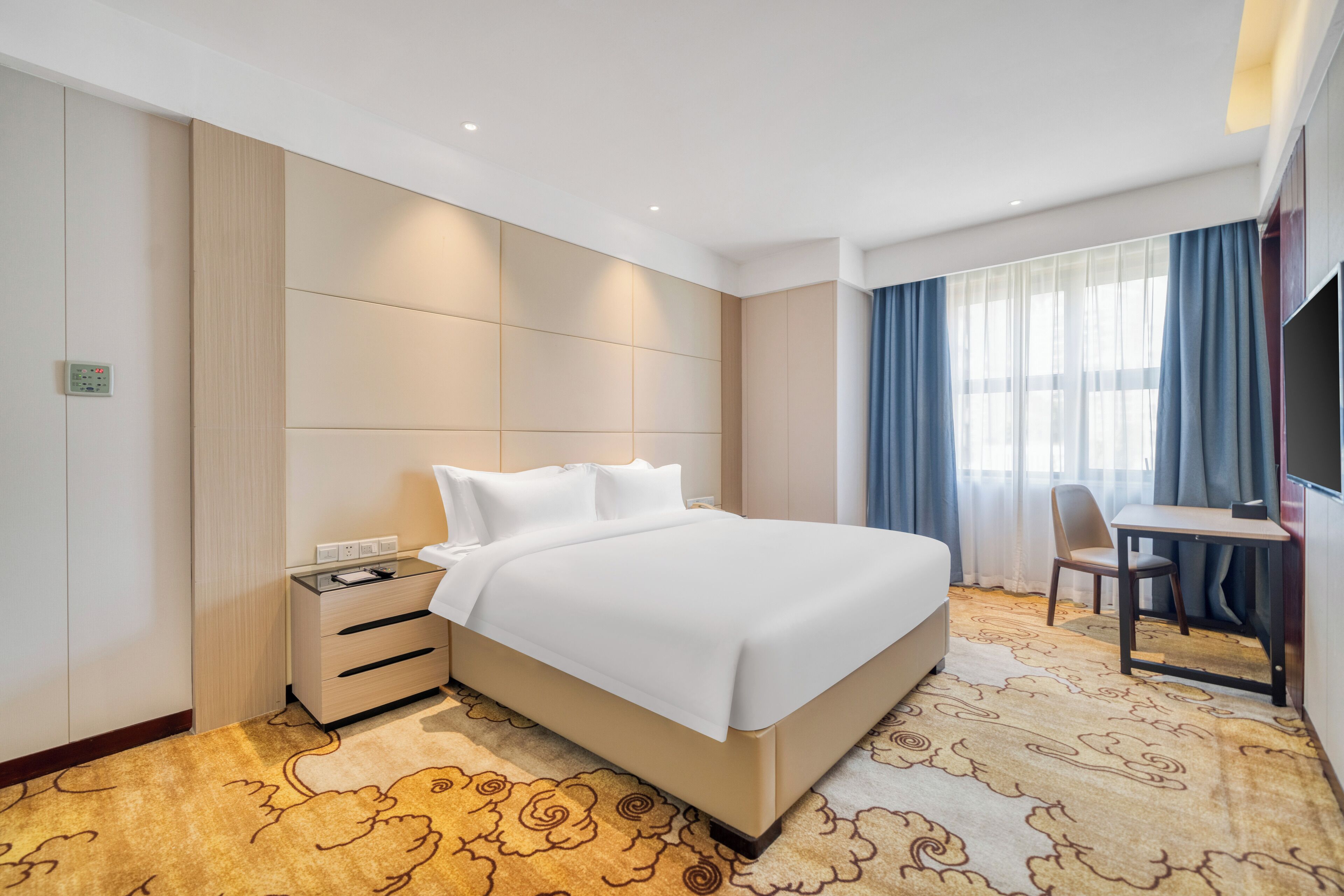 Una habitación de hotel con una cama grande, un escritorio y una silla.