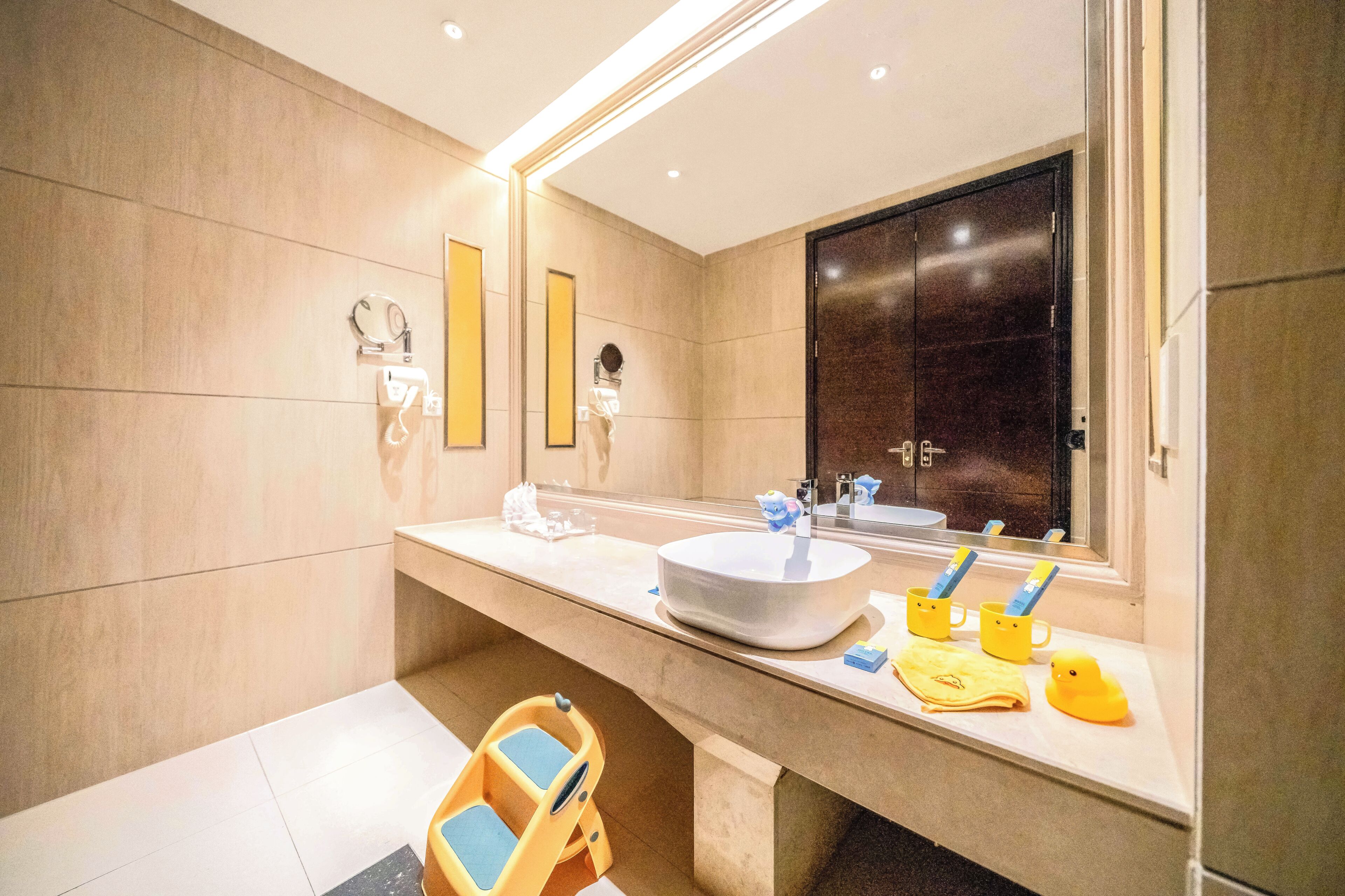 A modern bathroom with a large mirror, a sink, and a vanity.