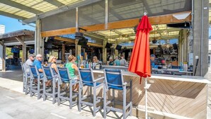 An outdoor seating area with metal chairs and a red umbrella. - Maison de La Mer by Stay on 30a (Inlet Beach)