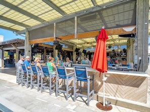 An outdoor seating area with metal chairs and a red umbrella.