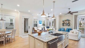 A spacious kitchen with a central island, pendant lighting, and a ceiling fan. - Maison de La Mer by Stay on 30a (Inlet Beach)